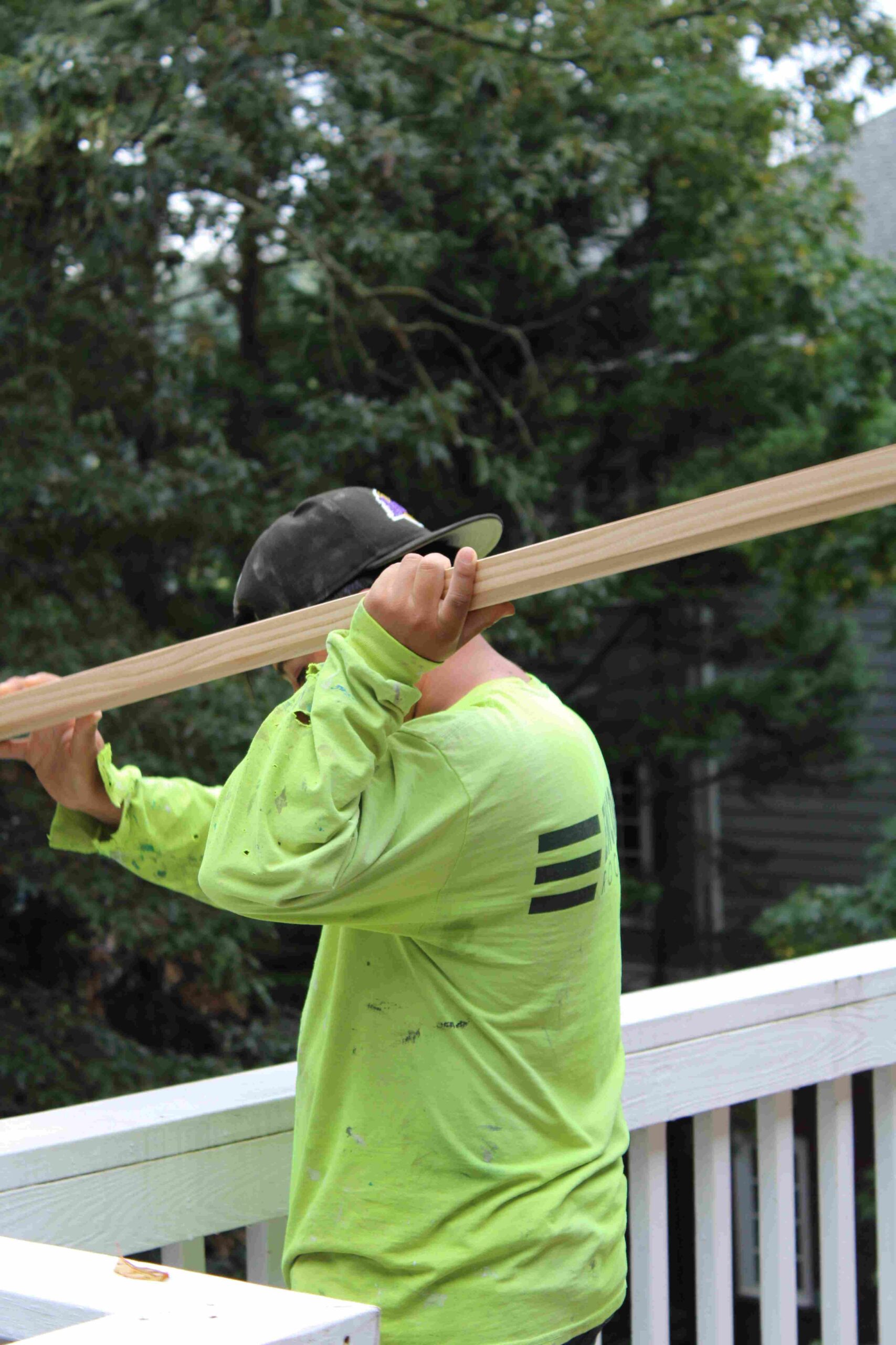 employee carrying plank